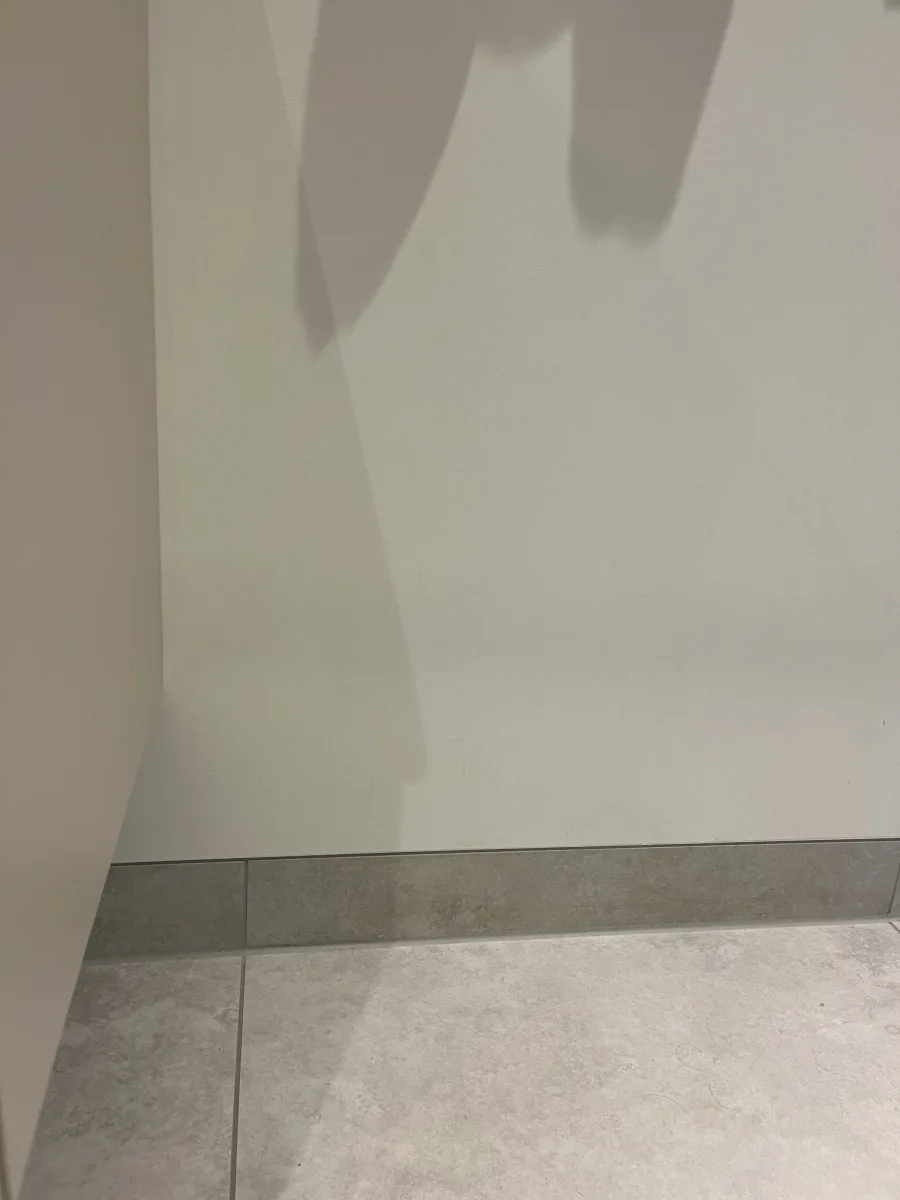 Plinttegel met stucwerk gelijk aan de voorzijde van de tegel