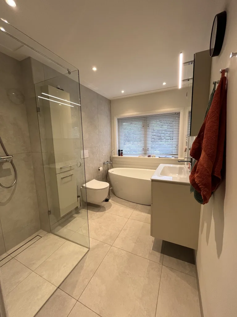 Gerenoveerde jaren 30 badkamer met inloopdouche van profielloos glas