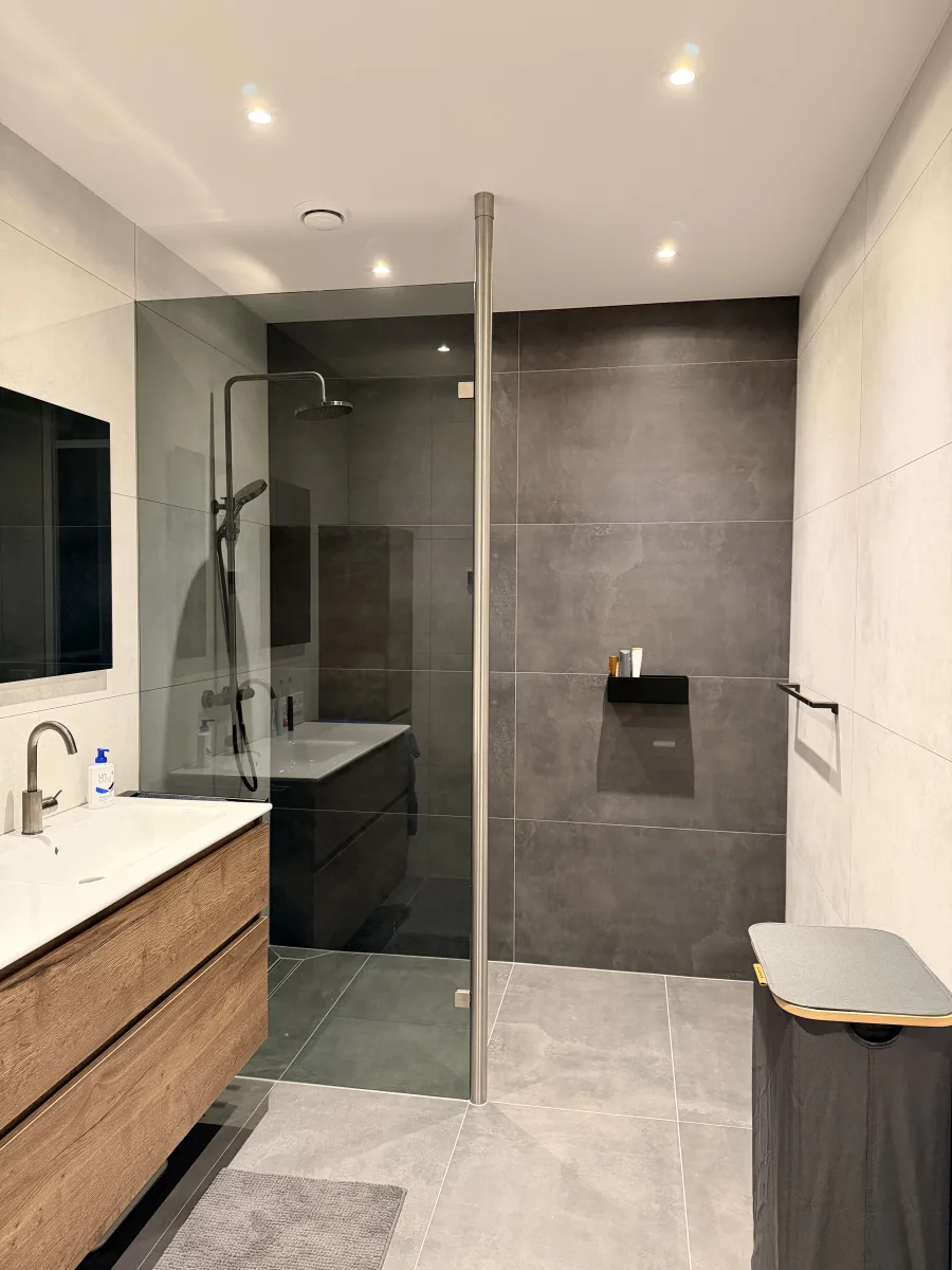 Rookglas, rvs-paal tot plafond en grote tegels: badkamer in Rhenen – modern stijl – Rhenen