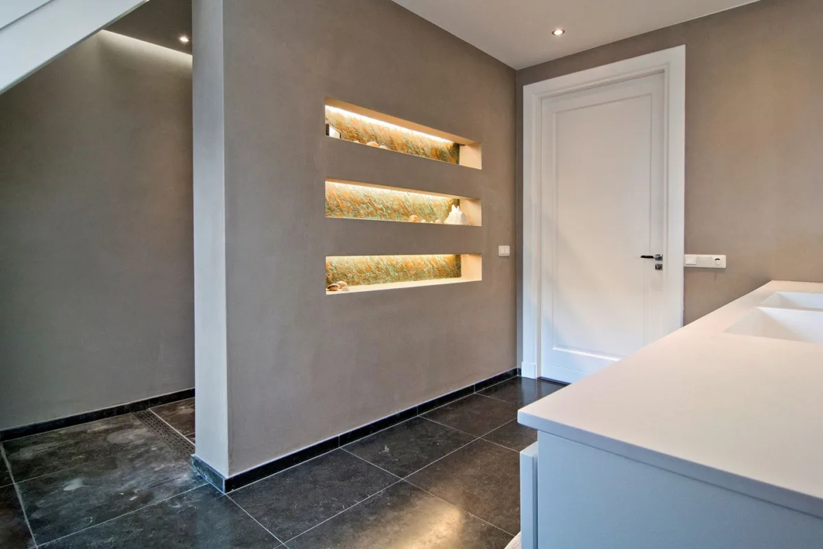 Badkamer met stucwerk en drie verlichte nissen in de wand