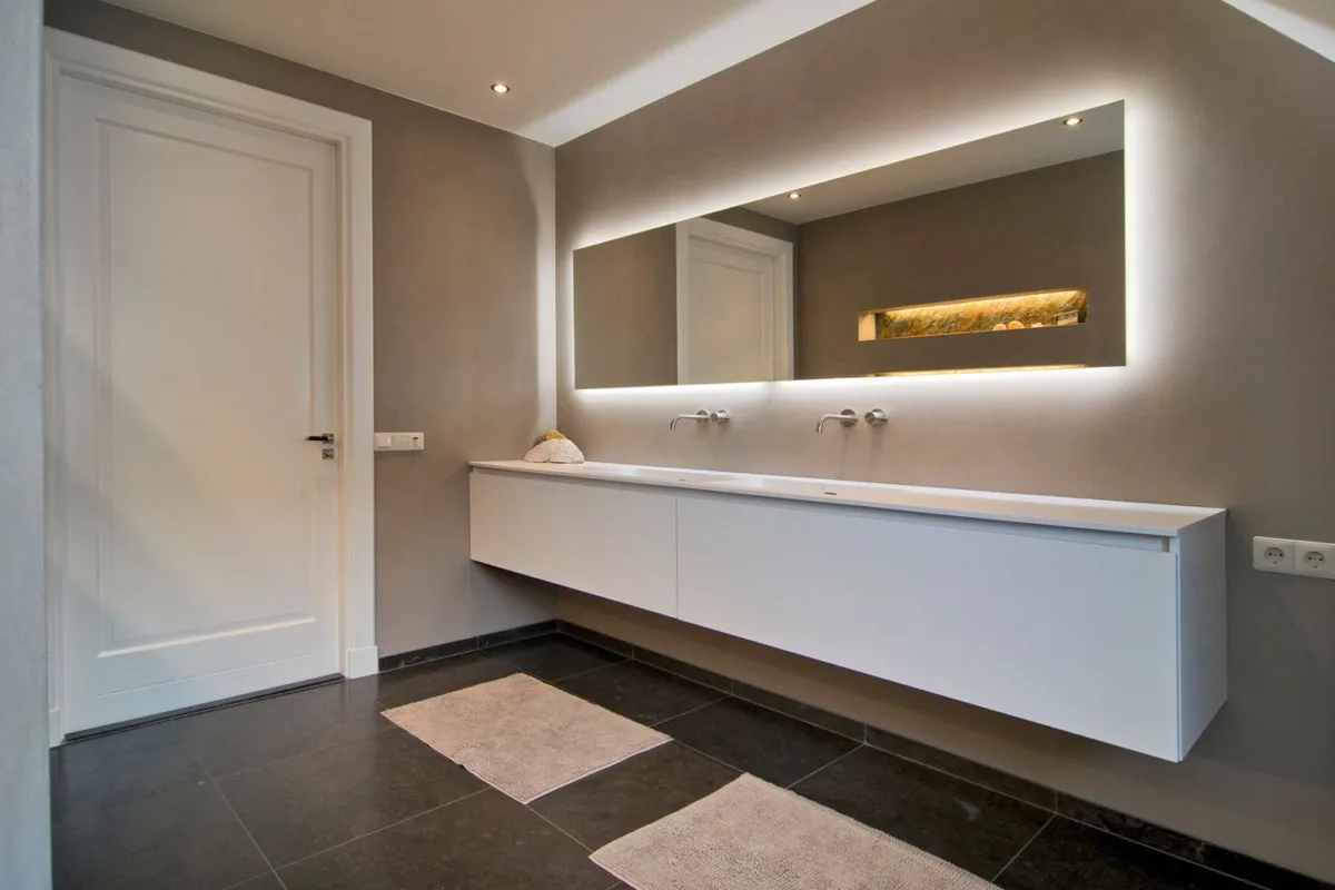 Badkamer met stucwerk, zwevend maatwerk badmeubel en spiegel met verlichting